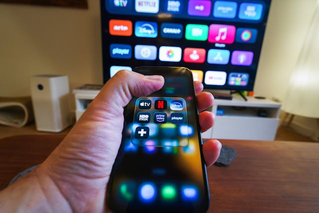A-hand-holding-a-phone-displaying-streaming-apps