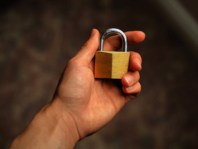 Hand-holding-a-brass-padlock-symbolizing-security-and-protection