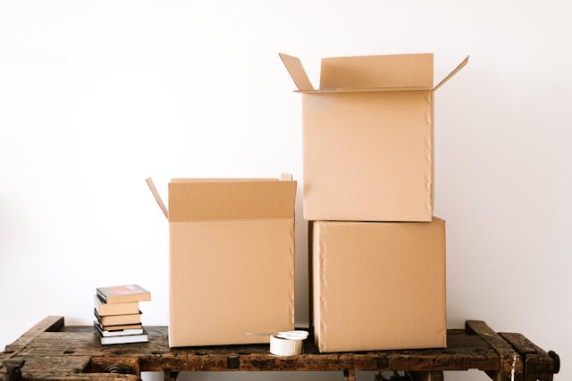 Stack of carton boxes and books on shabby table